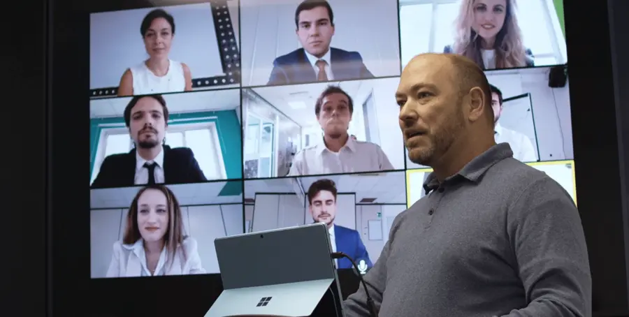 Training room with an instructor and remote participants on a wall display