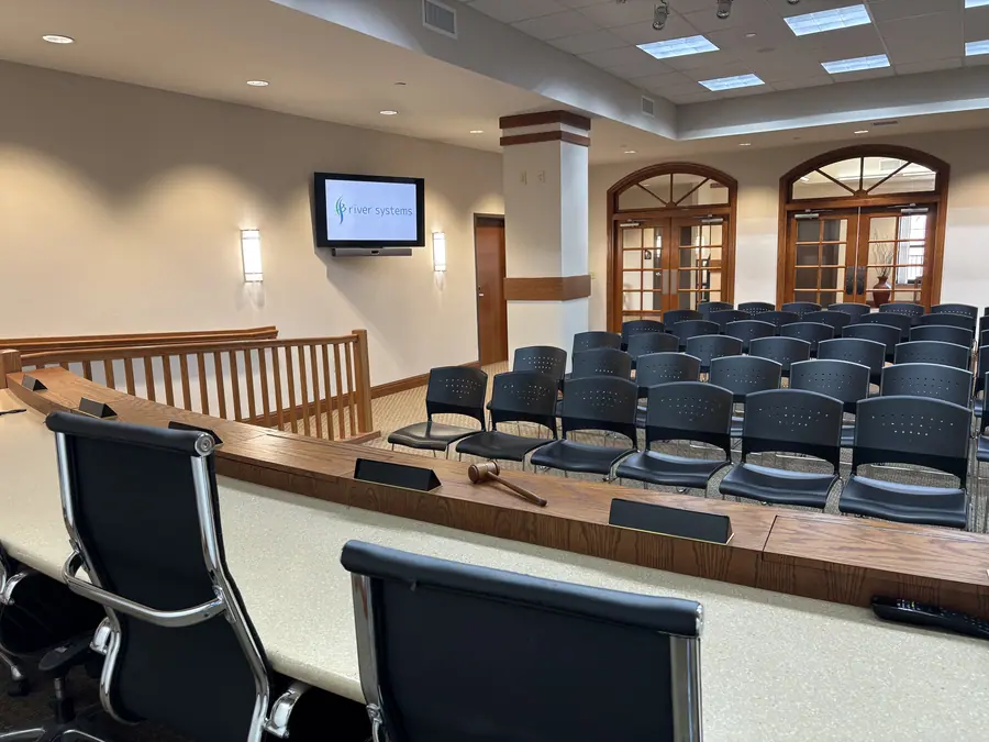 Public meeting chamber with a dais and audience seating