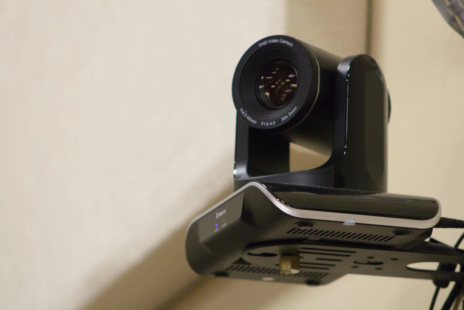 Wall mounted PTZ camera above a video conferencing bar